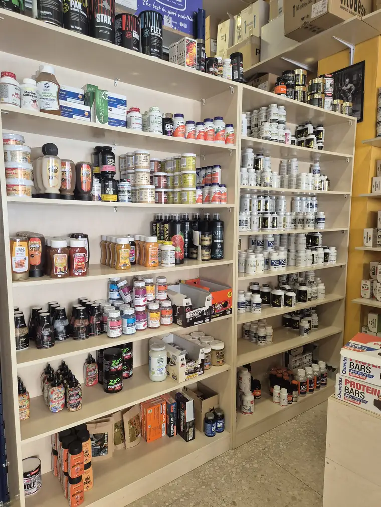 Pared de estanterías con vitaminas, cápsulas y complementos